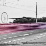 Strasse in Luzern mit Riesenrad im Hintergrund, Verkehr als Lichtspur