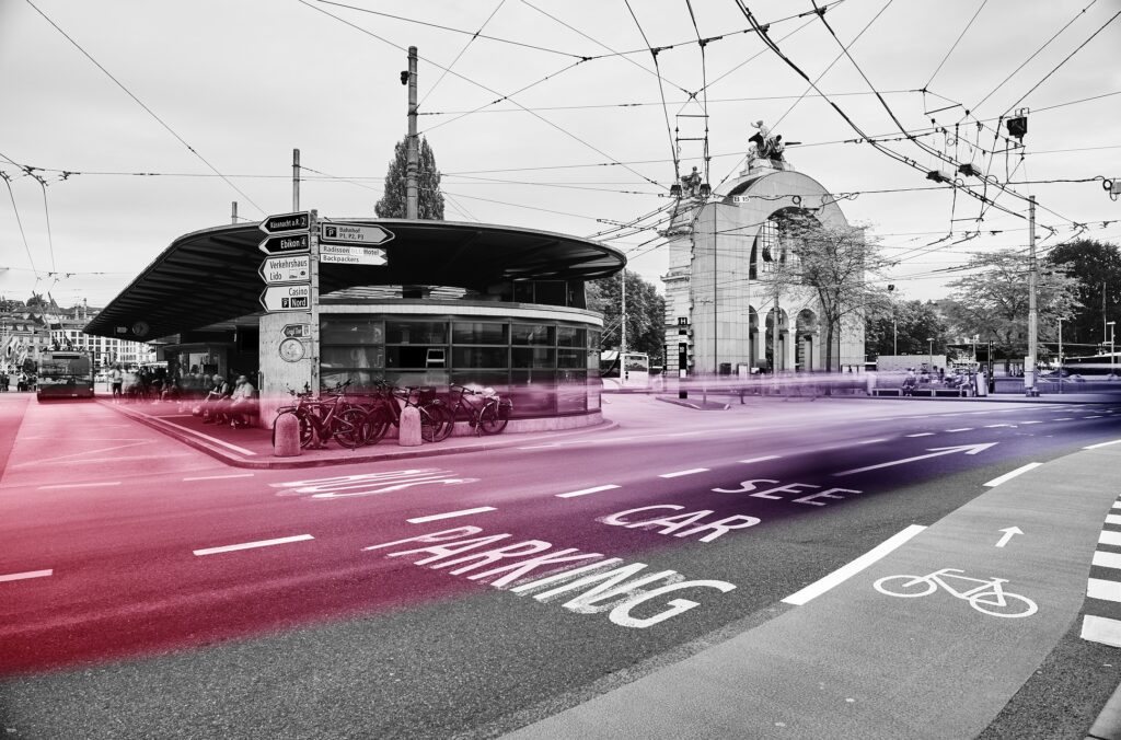 Bahnhofplatz Luzern mit historischem Torbogen, Verkehr als Lichtspur