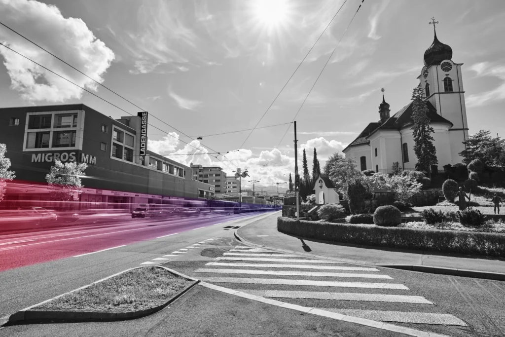 Strasse in Ebikon mit Kirche – Lichtspuren in Rosa und Violett