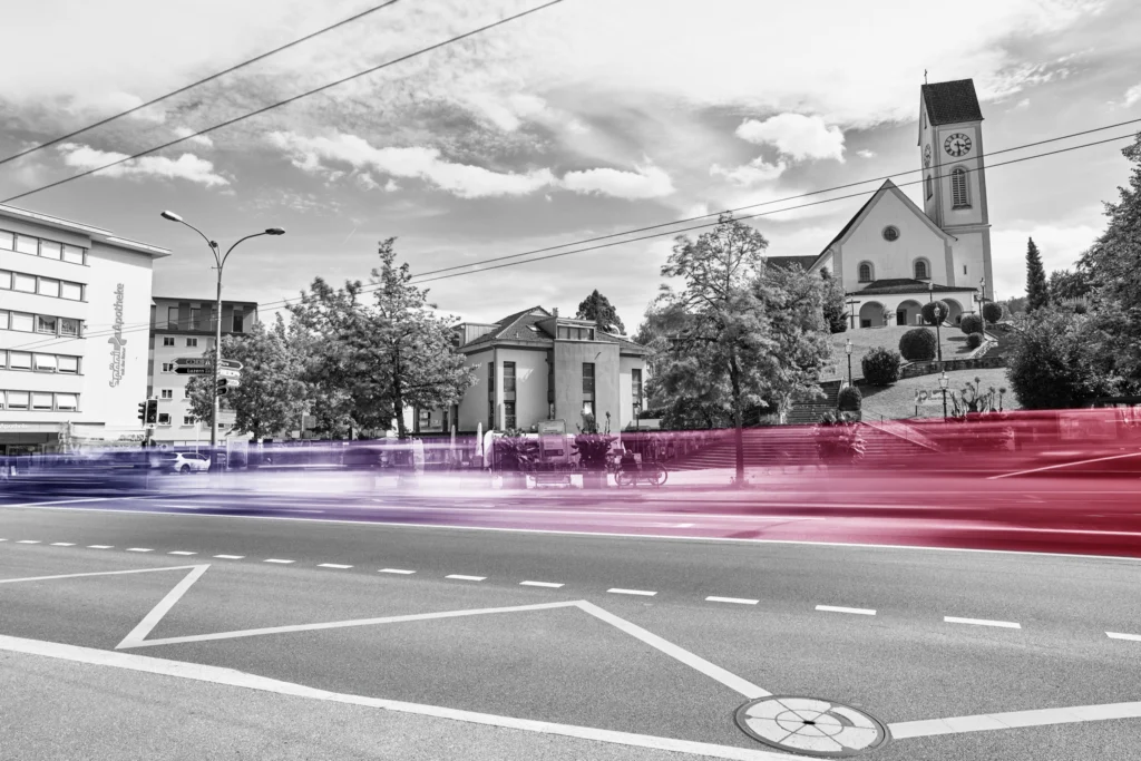 Strasse in Kriens mit Kirche – Lichtspuren in Rosa und Violett
